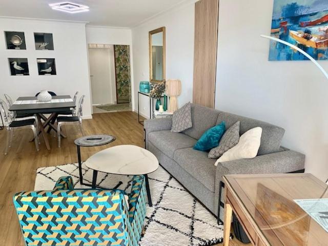 - un salon avec un canapé et un piano dans l'établissement Grand appartement les pieds dans l'eau, à La Baule