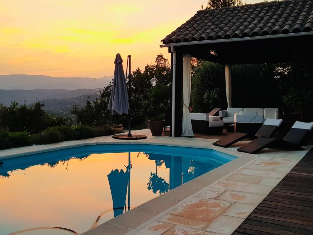 - une piscine avec un parasol à côté d'une maison dans l'établissement House with private pool & panoramic view, à Montauroux
