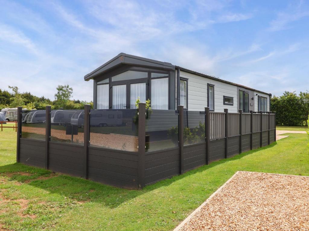 une maison avec une clôture noire dans une cour dans l'établissement Hazelnut Lodge, à Chipping Norton