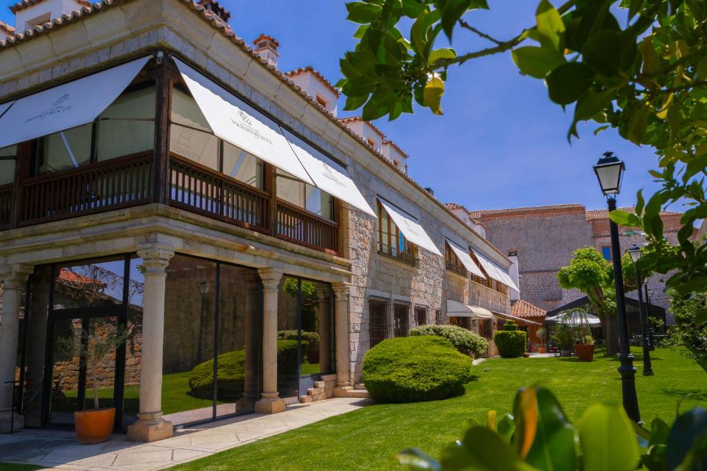 an exterior view of a building with a green lawn at La Casa del Presidente in Avila