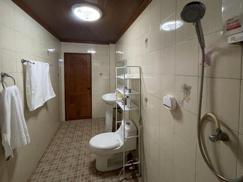 a bathroom with a toilet and a shower at Yoga Bed and Breakfast in Chiang Mai