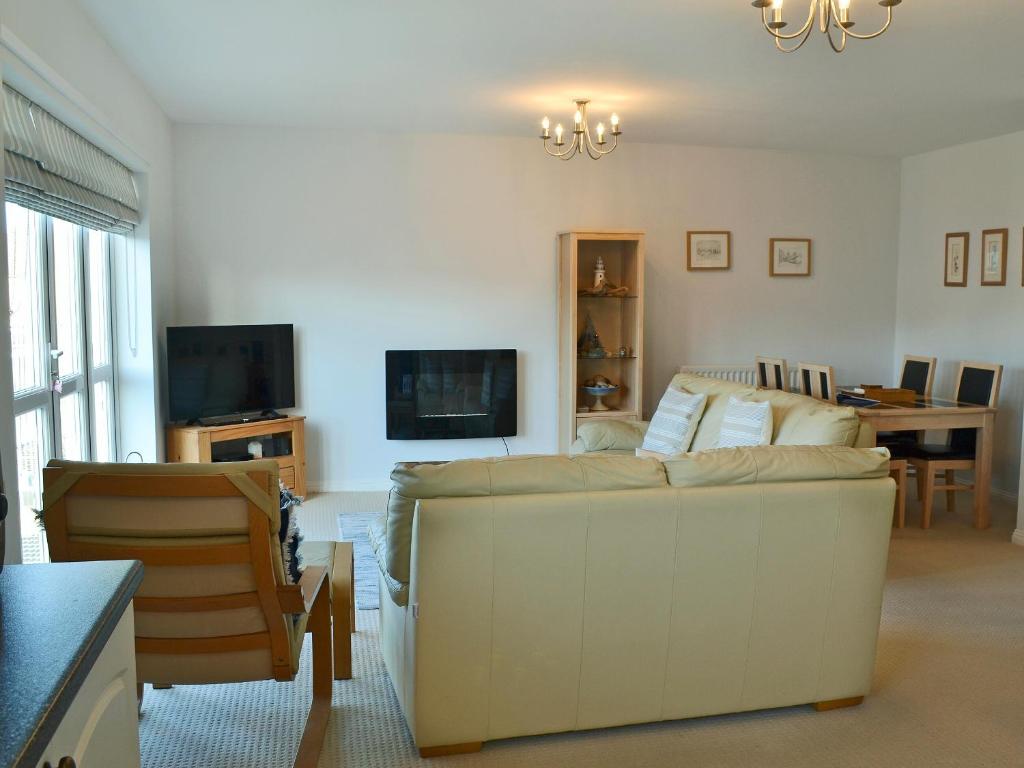 a living room with a couch and a tv at Captain Ron's in Beadnell