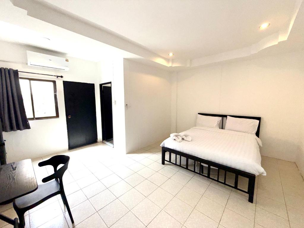 une chambre avec un lit et une chaise dedans dans l'établissement Patong Canal Villa R101, à Patong Beach