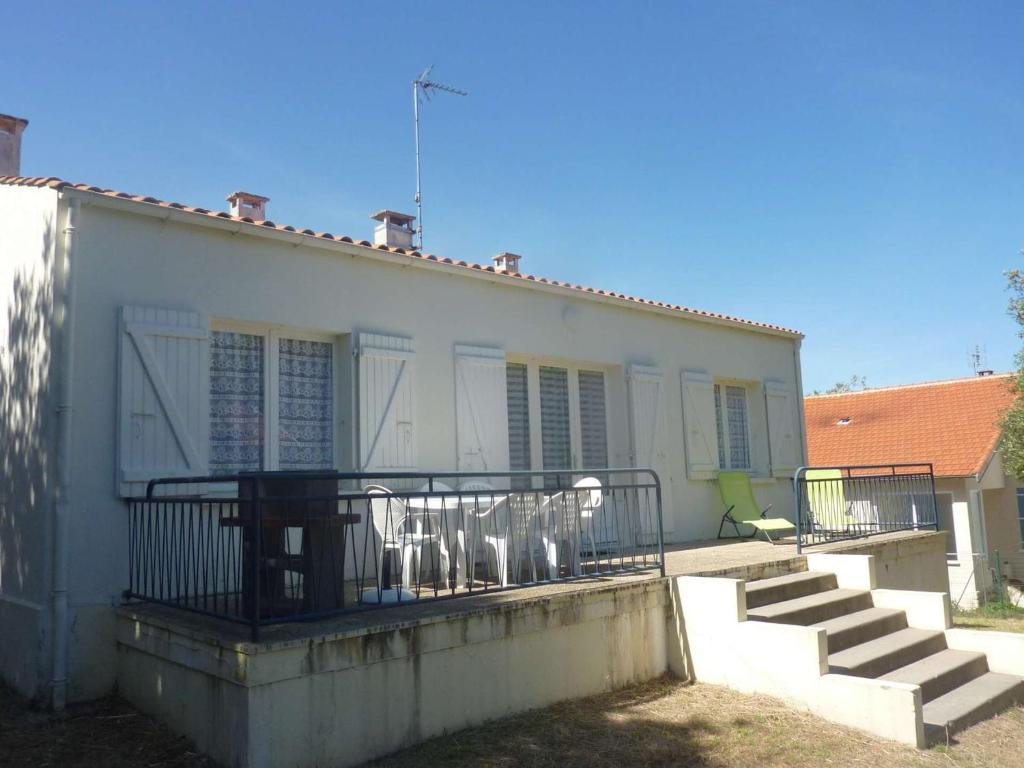 Cette maison blanche dispose d'un balcon avec des chaises. dans l'établissement Maison 4 pièces proche plage, Saint-Trojan-les-Bains - FR-1-246A-362, à Saint-Trojan-les-Bains
