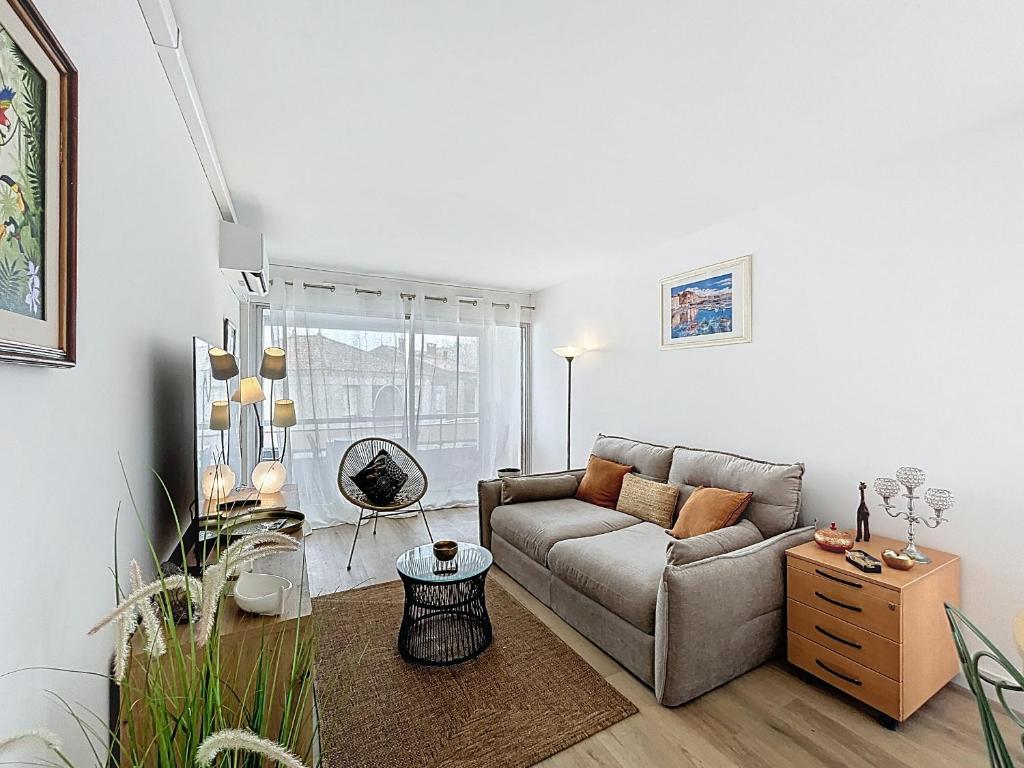 un salon avec un canapé et une table dans l'établissement Appartement sur plage avec parking privé pour 4 pers - FR-1-715-107, à Mauguio