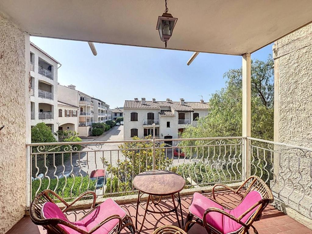 d'un balcon avec des chaises roses et une table. dans l'établissement Appartement familial près de la plage avec parking - FR-1-770-54, à Saint-Cyr-sur-Mer