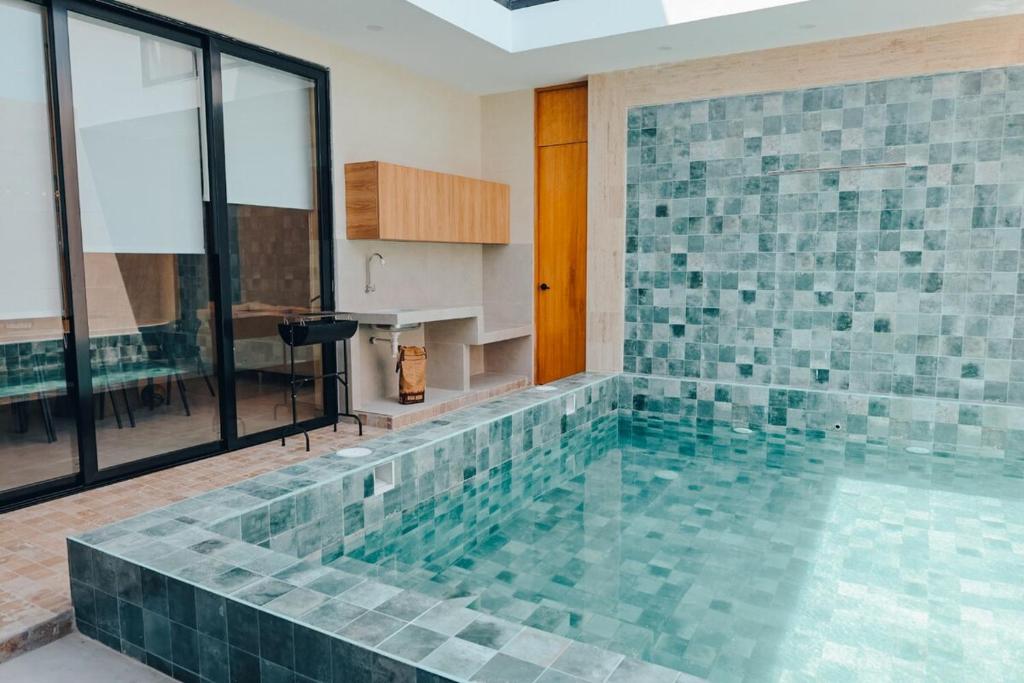 a large swimming pool with a tile wall at Cozy big house in Paracas