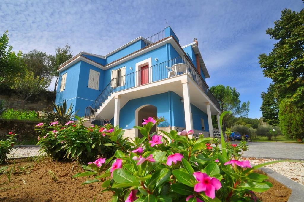 a blue house with pink flowers in front of it at La Casa Blu in Mirabella Imbaccari