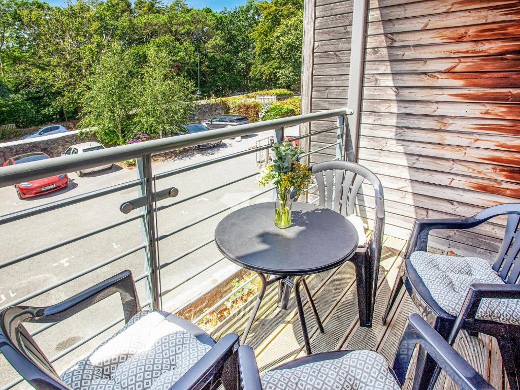 een tafel en stoelen op een balkon met een vaas met bloemen bij 4 Water Wheel Apartment in Charlestown