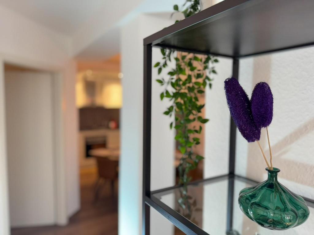 eine Glasvase mit lila Blumen in einem Zimmer in der Unterkunft Exklusives 3 Zi Design Apartment in FR-Altstadt in Freiburg im Breisgau