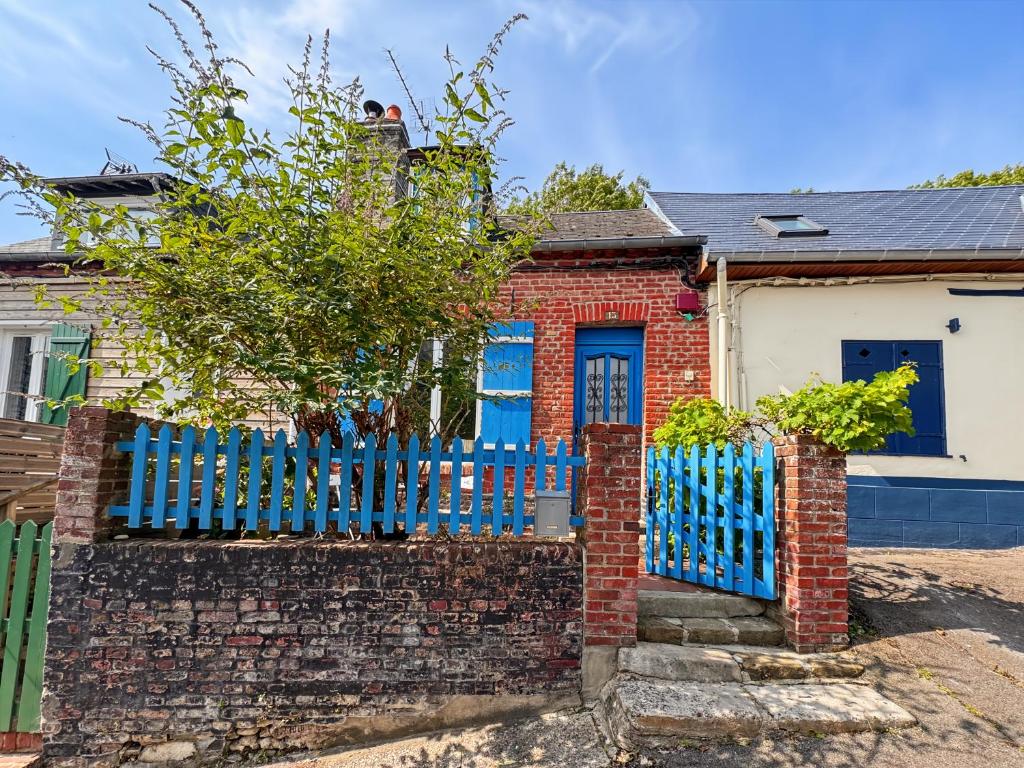 une maison en briques rouges avec une clôture bleue dans l'établissement CALME ET AUTHENTICITE AU COEUR DU COURTGAIN, à Saint-Valery-sur-Somme