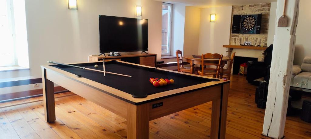 Una sala de estar con una mesa de billar con fruta encima. en Le loft, en Bar-sur-Aube