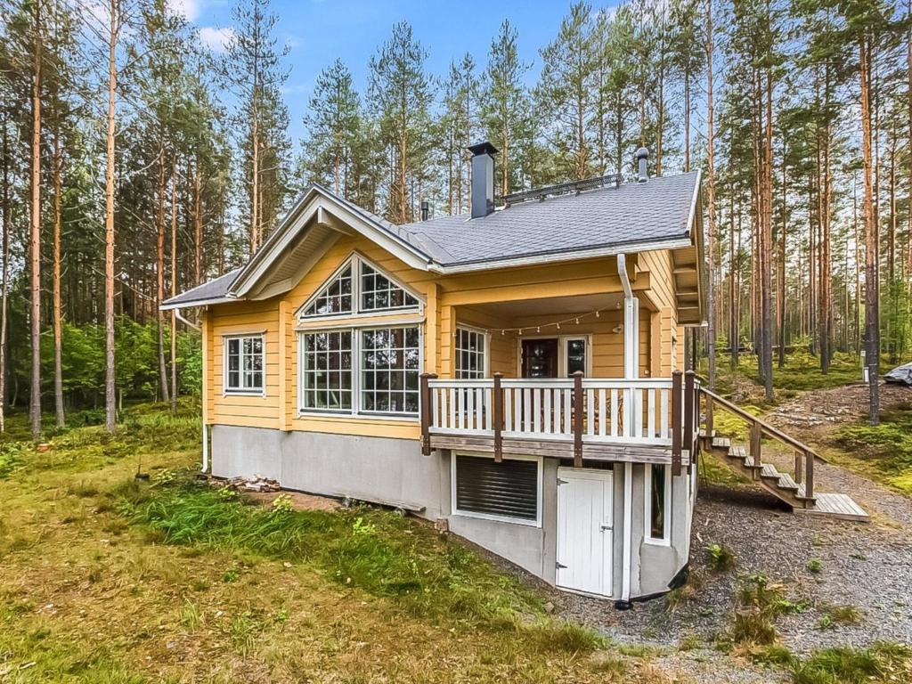 ein winziges Haus mit einer Terrasse im Wald in der Unterkunft Holiday Home Villa niemelänranta by Interhome in Puumala