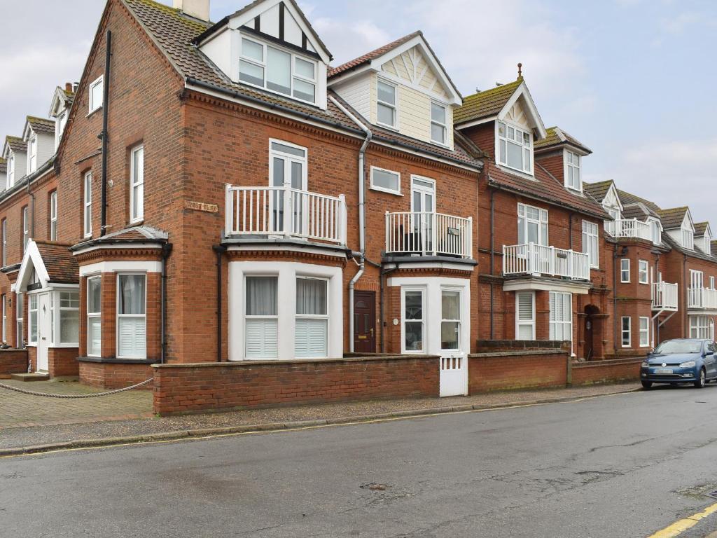 a large brick building with a car parked in front of it at Sandrock House in Sheringham