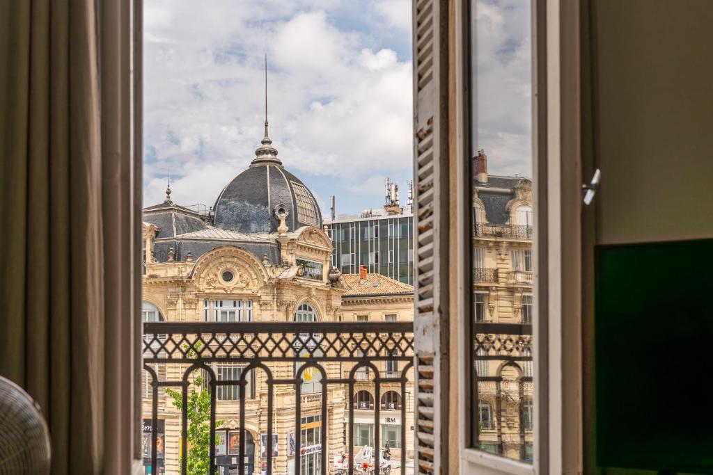 - une vue sur un grand bâtiment depuis une fenêtre dans l'établissement Exceptionnel appartement avec vue Place de la Comédie, à Montpellier