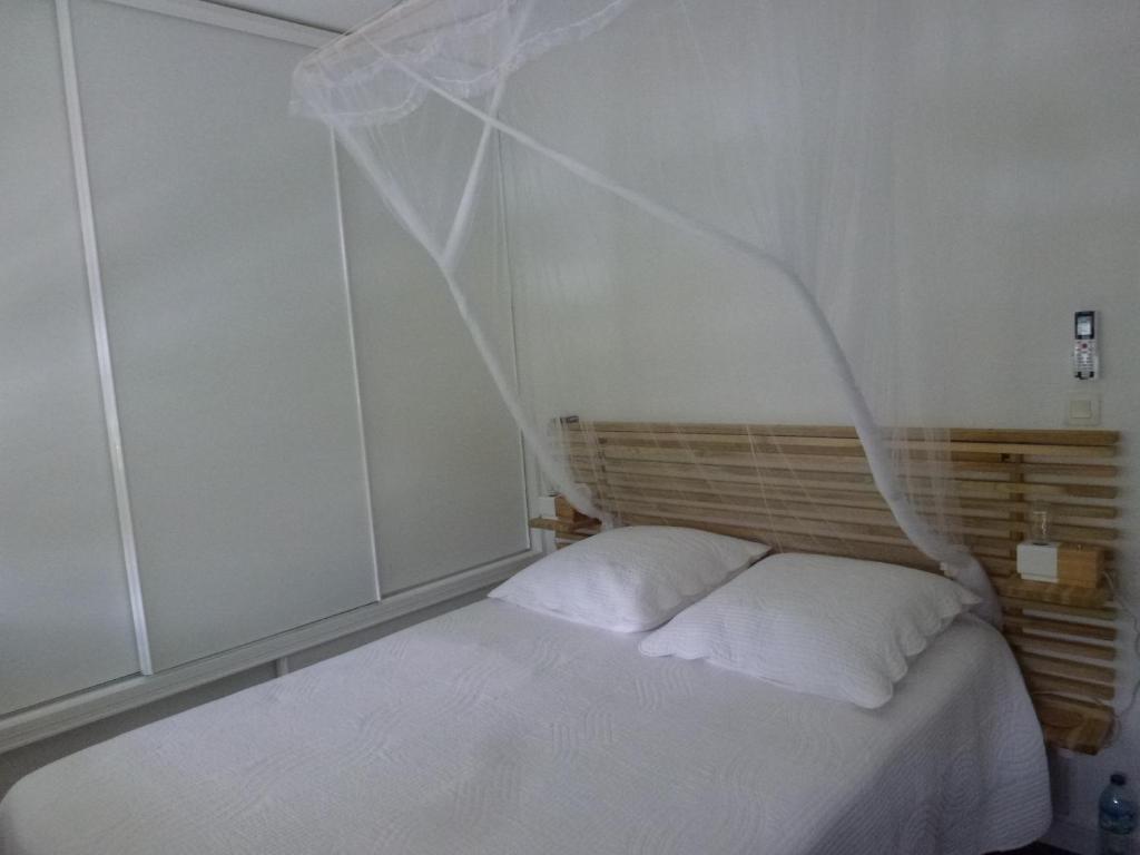 a bedroom with a white bed with white sheets at Bonite in Les Trois-Îlets