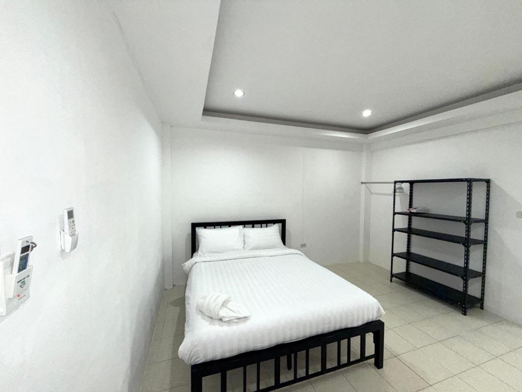 パトンビーチにあるPatong Canal Villa 110のベッドルーム1室(白いシーツと棚付きのベッド1台付)