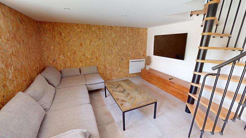 a living room with a couch and a table at Grand appartement avec piscine in Clermont-Ferrand