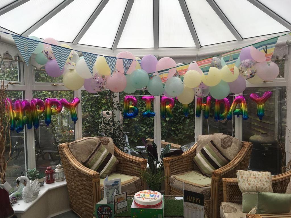 a bunch of balloons are hanging in a conservatory at Northern homestay between High Peak & Manchester in Hadfield