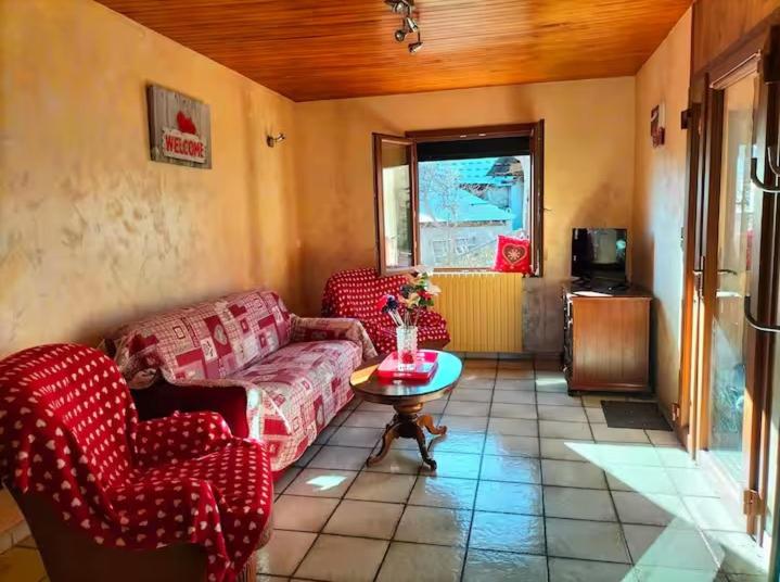 un salon avec des canapés rouges et une table dans l'établissement Lieu dit les Allemands, à Embrun