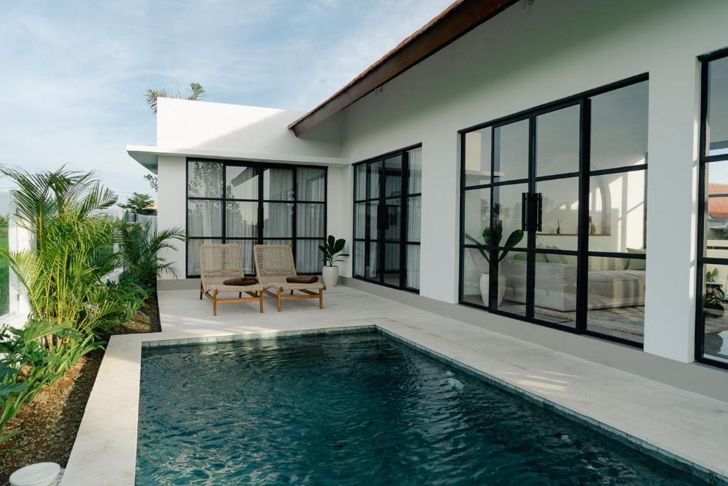 a swimming pool in front of a house at Villa Alaya No 4 in Cemagi