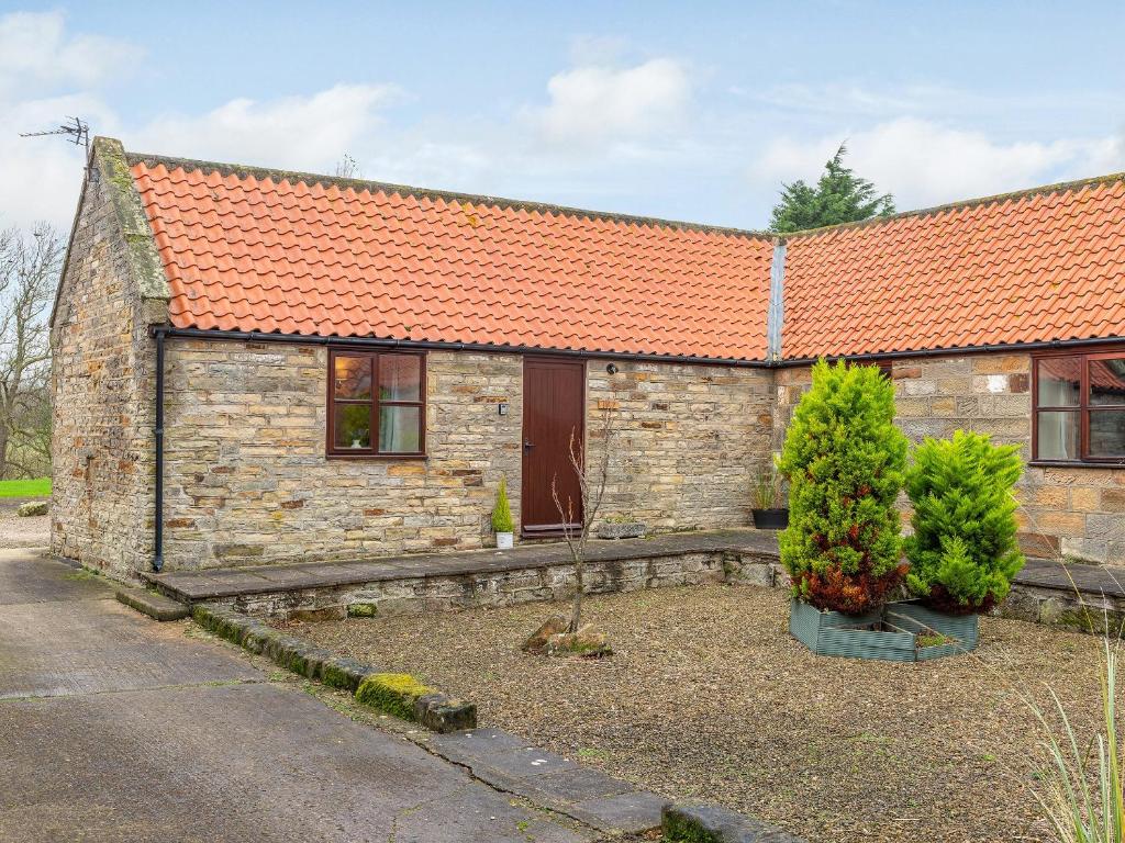 an old stone house with an orange roof at Maybeck Cottage in Whitby