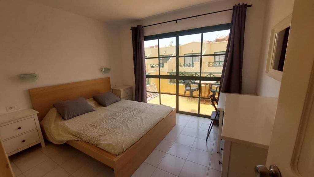 a bedroom with a bed and a large window at Castillo Mar in Caleta De Fuste