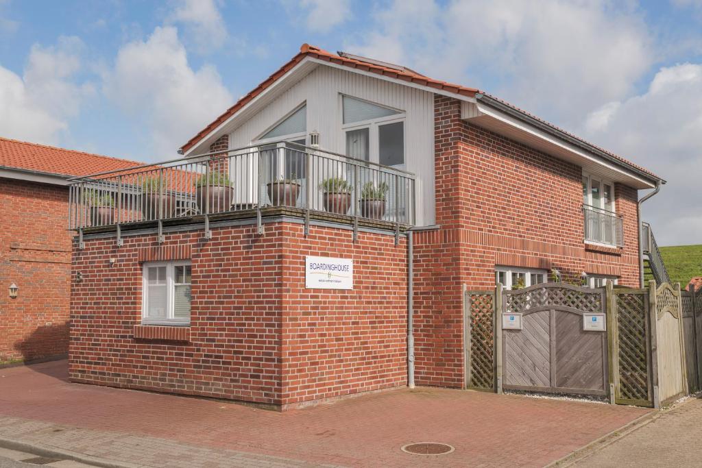 a brick house with a balcony on top of it at Boardinghouse in Büsum
