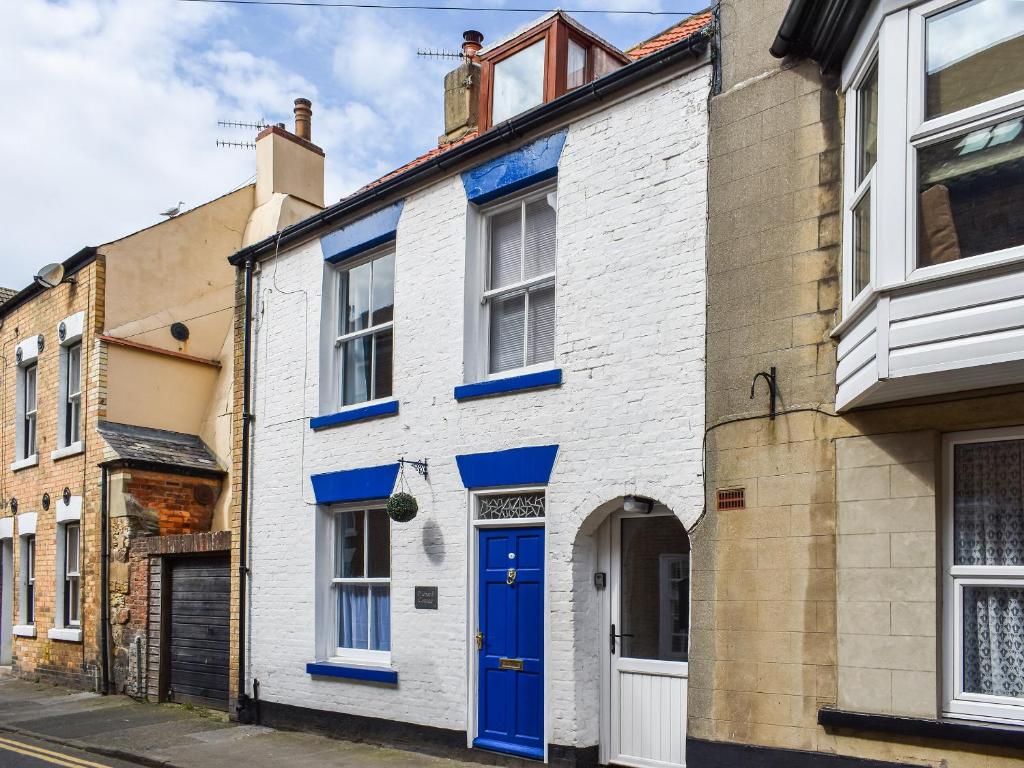 a house with a blue door on a street at Pilchard Cottage in Scarborough