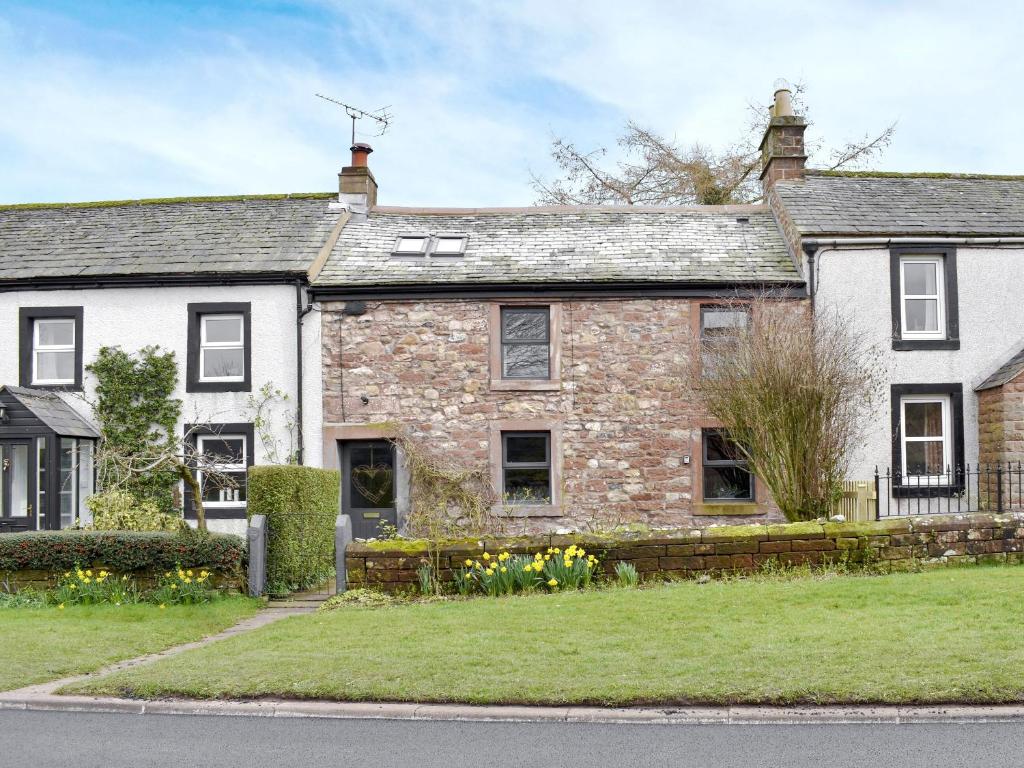 an old stone house on the side of a street at Toms Cottage in Melmerby