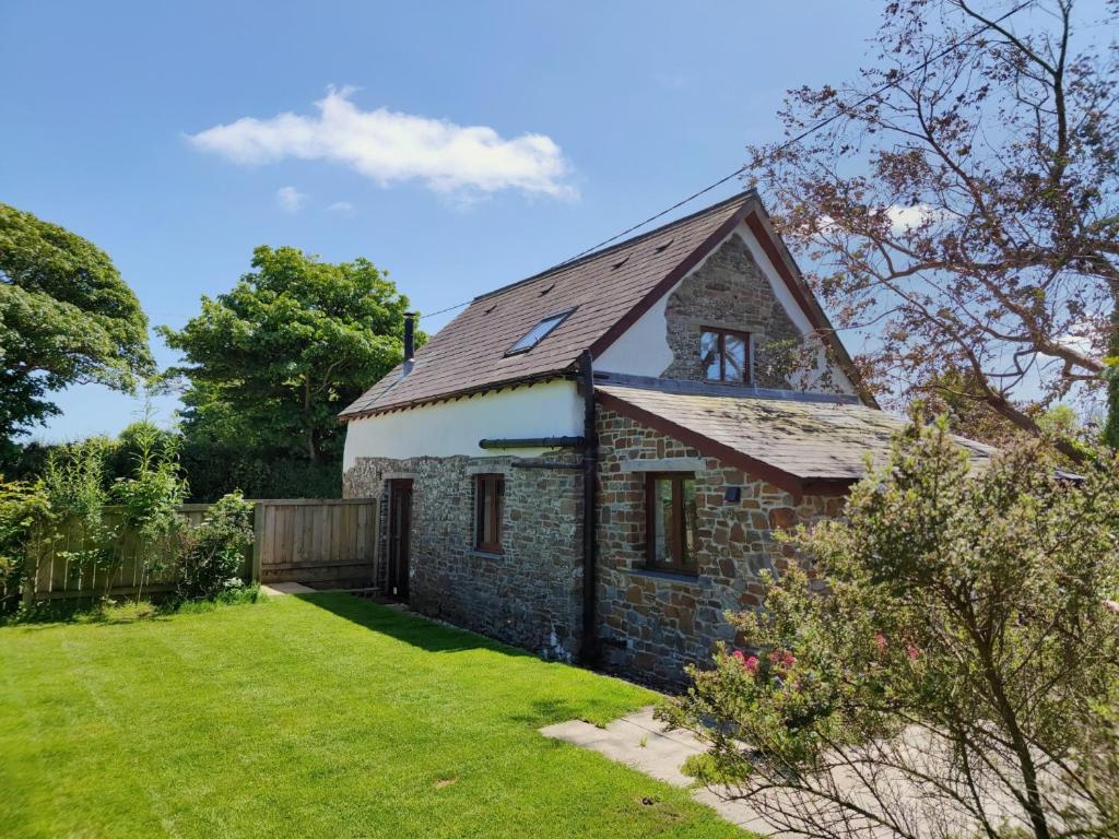una antigua casa de campo de piedra con un patio de césped en 1 bed property in Hartland 86571, en Hartland