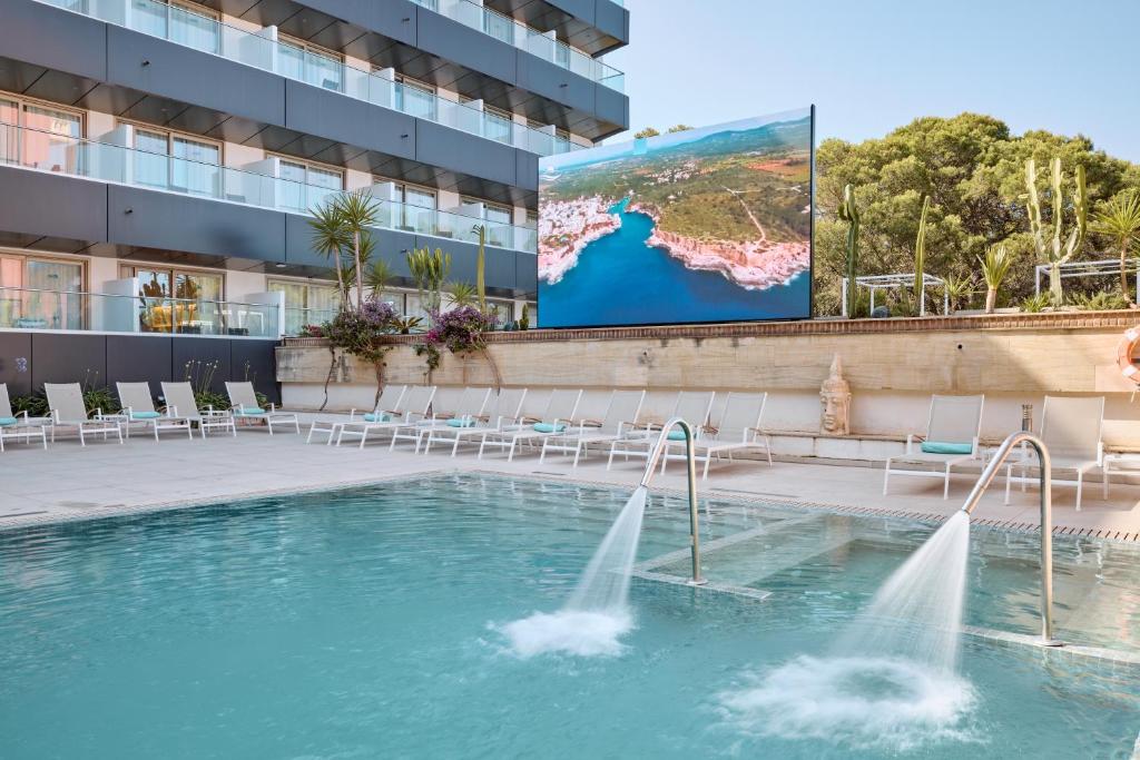 a pool with water jets in front of a building at Hotel Ipanema Beach in El Arenal