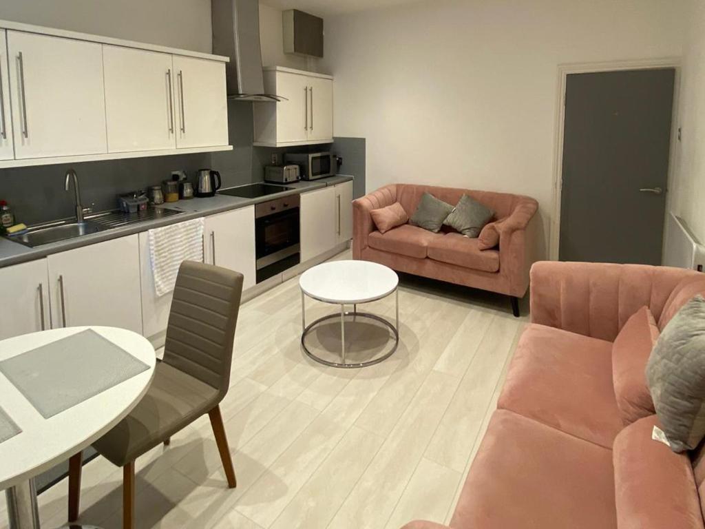 a kitchen and living room with a couch and a table at New York Apartment in Sheffield
