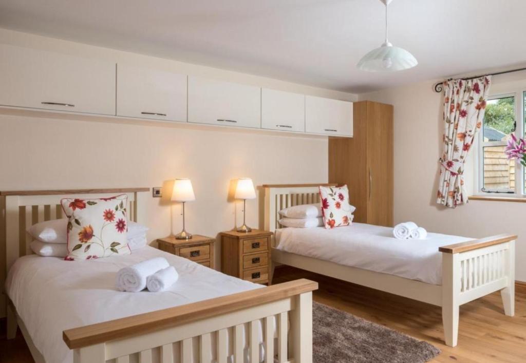 a bedroom with two beds and two lamps at 2 Bed House - Sleeps 4 - Fishing - Parking - Patio in Abergavenny