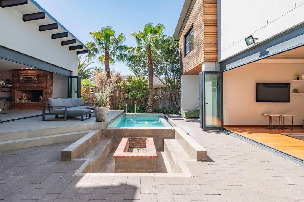 ケープタウンにあるFamily home in Tableview, close to Dolphin Beach.の裏庭(スイミングプール、家あり)
