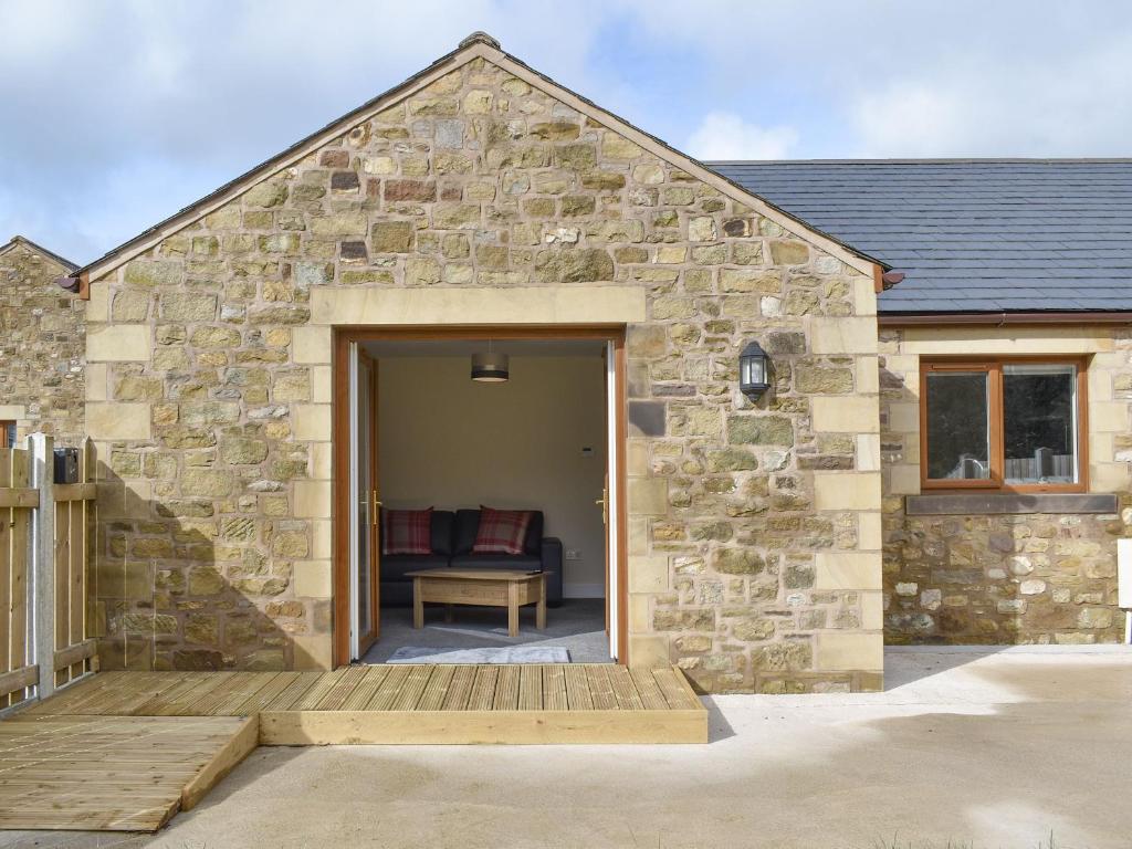 a stone house with a wooden door and a patio at Five Dorchester Drive - Uk32043 in Inglewhite