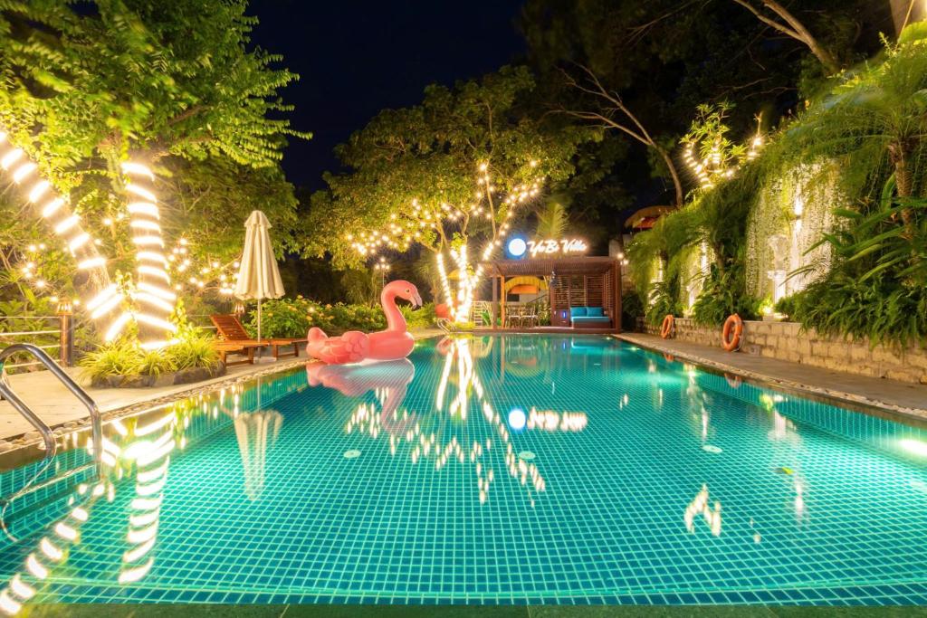 a swimming pool at night with flamingos in the water at Yubi Villa Private Swimming Pool 100m2 - Super Vip in Vung Tau
