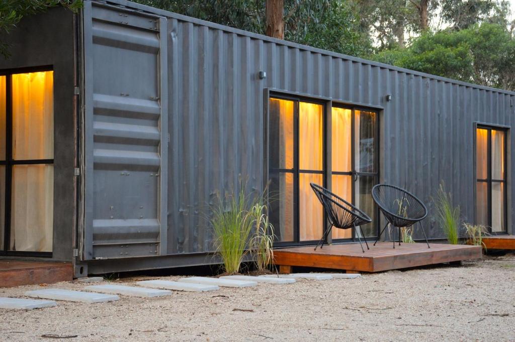 un bâtiment en métal avec quelques chaises devant dans l'établissement Moka - Holiday Home by the Sea, à Barra de Portezuelo