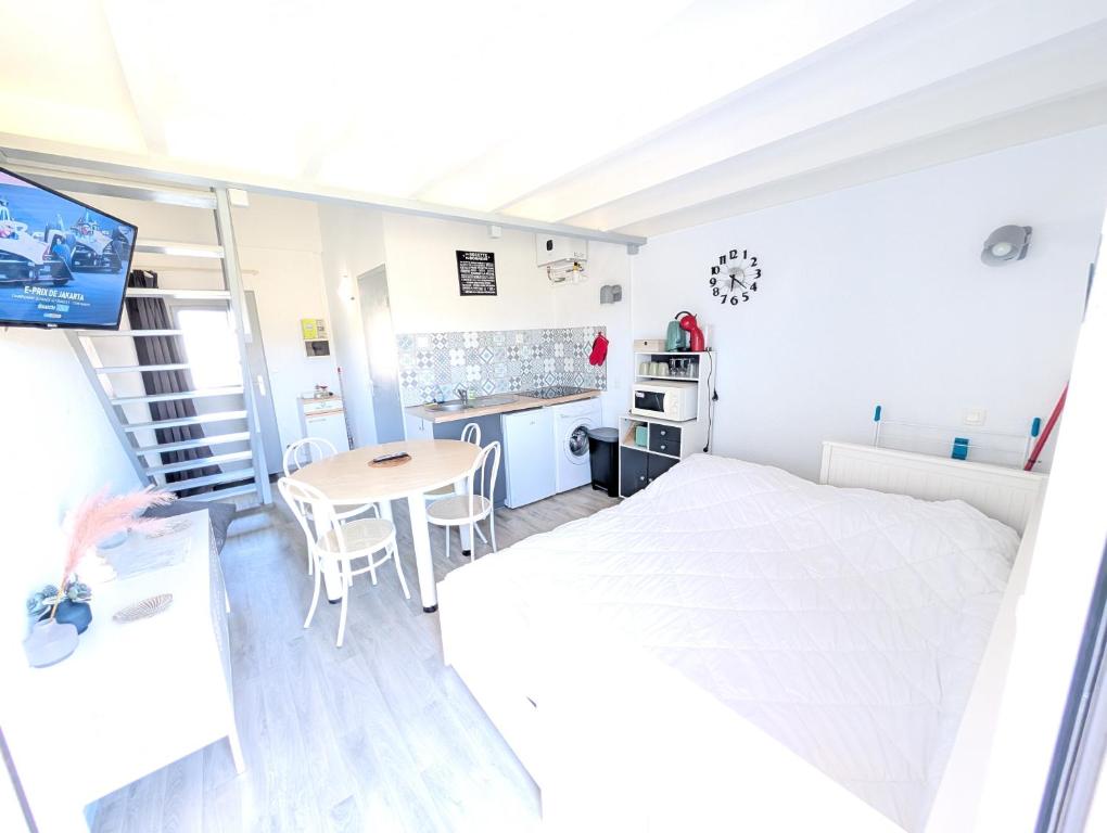 une chambre avec un lit et une table et une cuisine dans l'établissement Le Futuronid, à Chasseneuil-du-Poitou