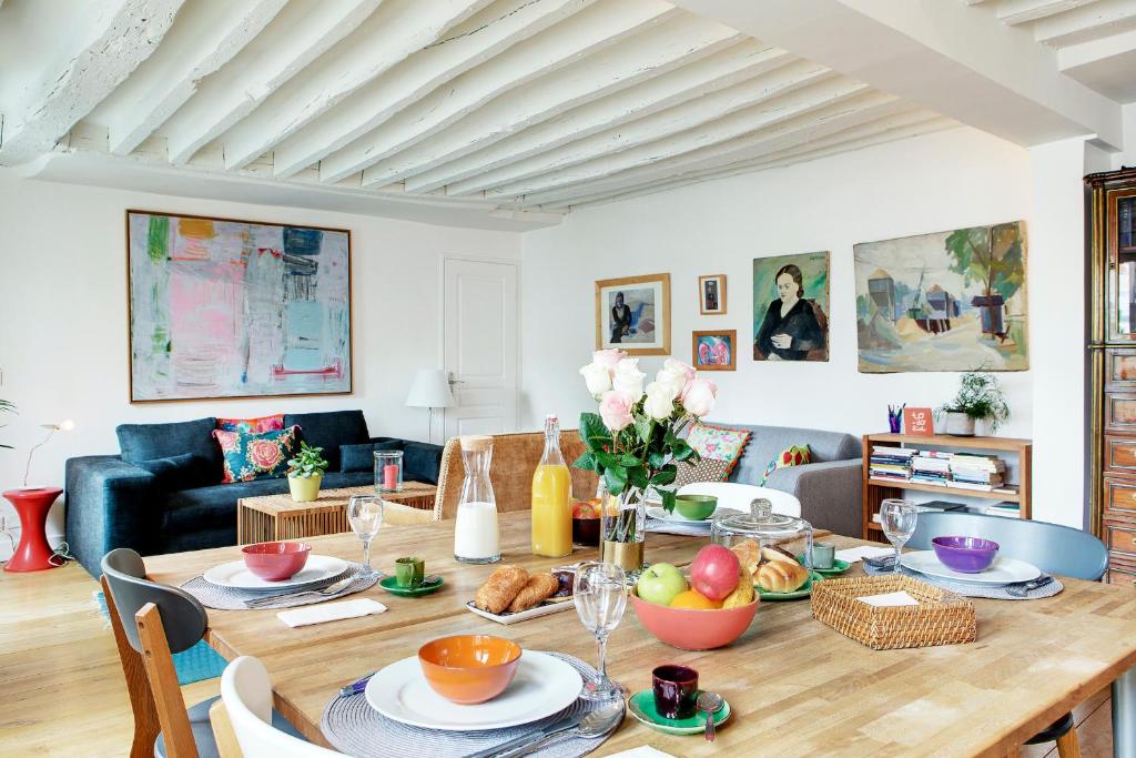 une salle à manger avec une table sur laquelle se trouve de la nourriture dans l'établissement Paris Bastille Rollin residence, à Paris