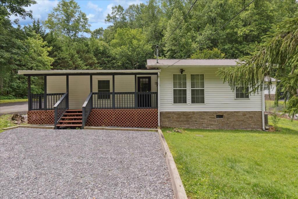a home with a screened porch and a driveway at Creekside Retreat Arcade Fire Pit in Pigeon Forge