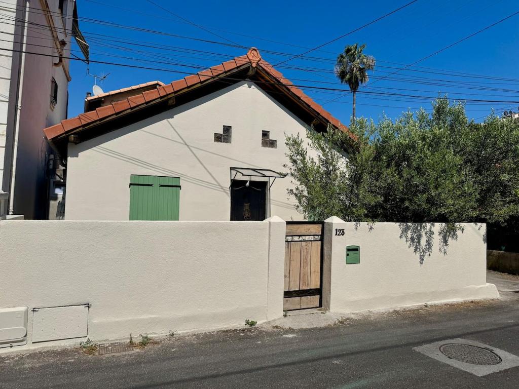 une maison blanche avec un portail et une clôture dans l'établissement Maison provençale en bord de mer, à Vallauris