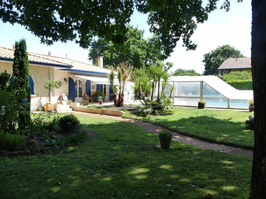 une maison avec une cour dotée d'une pelouse sidx sidx sidx dans l'établissement T2 Climatise sur le BASSIN D ARCACHON, à Gujan-Mestras