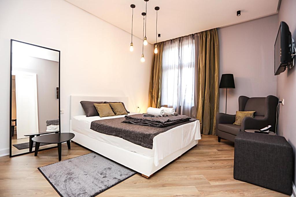 a bedroom with a large white bed and a mirror at Moment Boutique Apartments in Belgrade