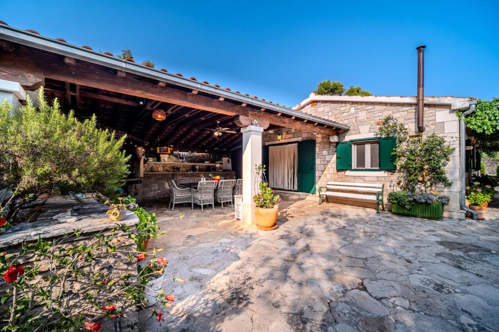 eine Terrasse eines Hauses mit einem Tisch und Stühlen in der Unterkunft Holiday Home Sarbunara in Milna