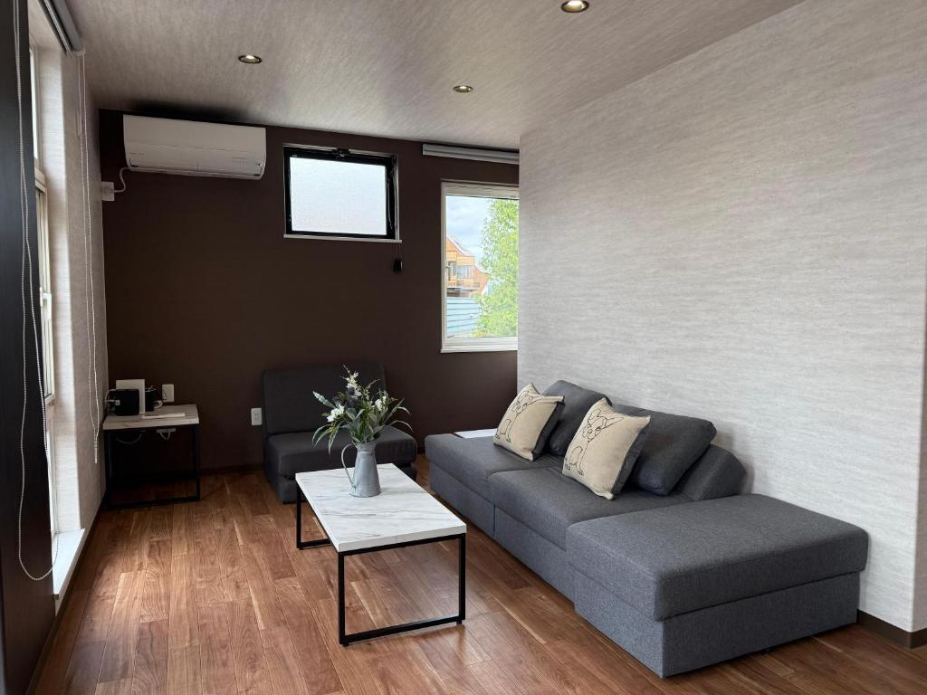 a living room with a couch and a table at Full House Furano in Furano
