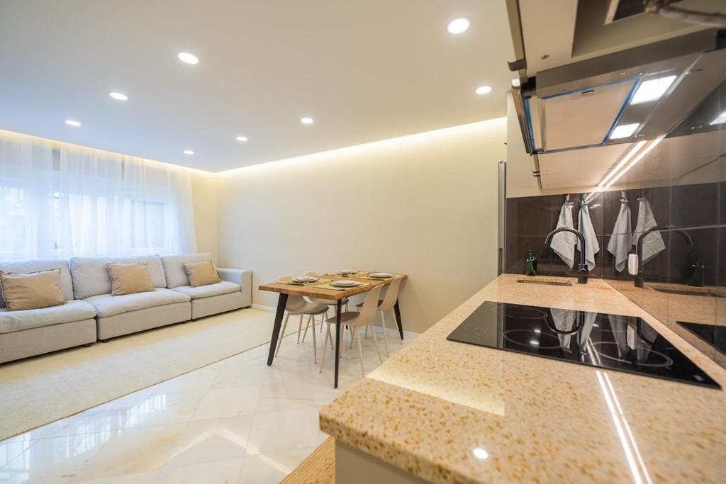 Una cocina y una sala de estar con un sofá y una mesa. en Cascais Apartment, en Cascais