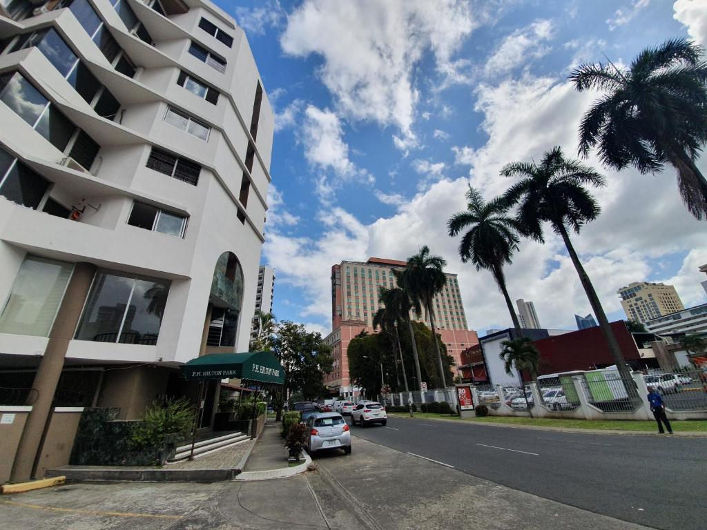 a street in a city with palm trees and a building at Apartamento cerca del Metro y Hoteles El Cangrejo in Panama City