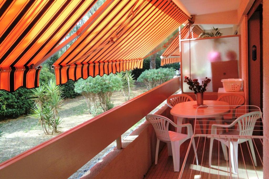 un balcon avec une table, des chaises et une fenêtre dans l'établissement agréable appartement 3 pièces 62 m2, à Hyères