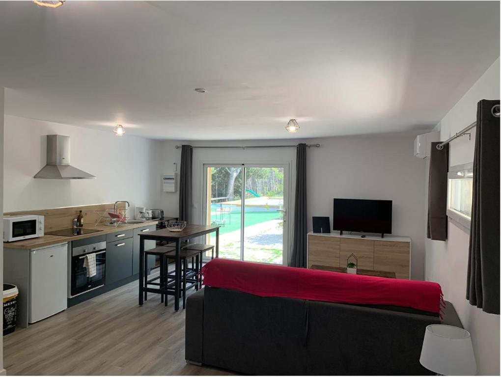 a living room with a couch and a kitchen with a table at Le Grenadier in Saint-Mitre-les-Remparts